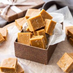 A bronze gift box filled with squares of salted caramel fudge.