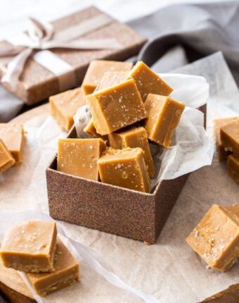 A bronze gift box filled with squares of salted caramel fudge.