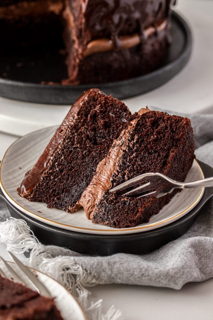 A closeup of a slice of chocolate cake with a fork digging into it