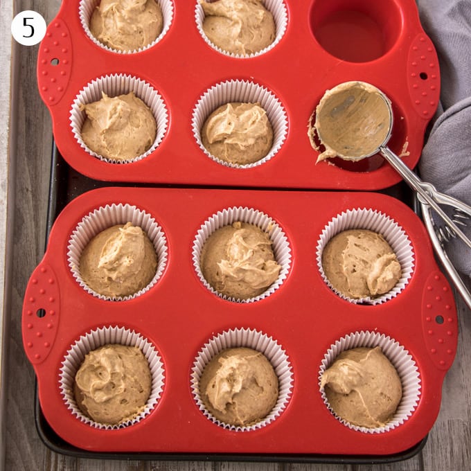 Cinnamon cupcake batter portioned out into cupcake cases in a muffin tin