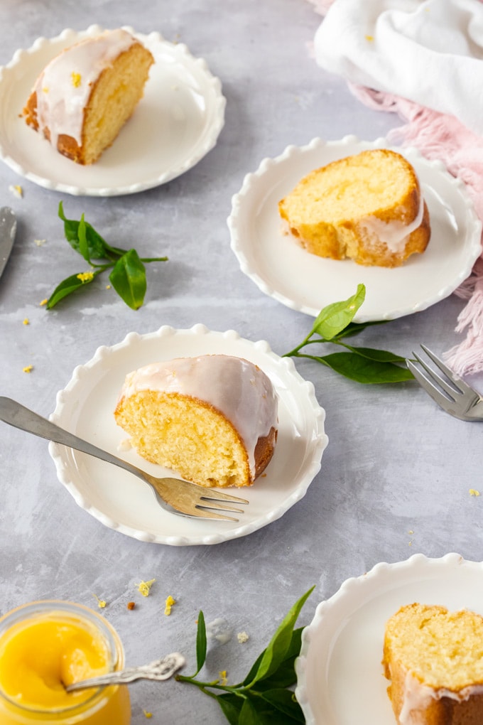 Lemon butter cake slices on white plates on a grey surface