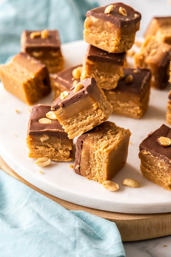 Pieces of caramel peanut fudge stacked up on a white platter