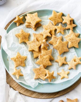 Birdseye view of a pastel green plate topped with star-shaped shortbread cookies