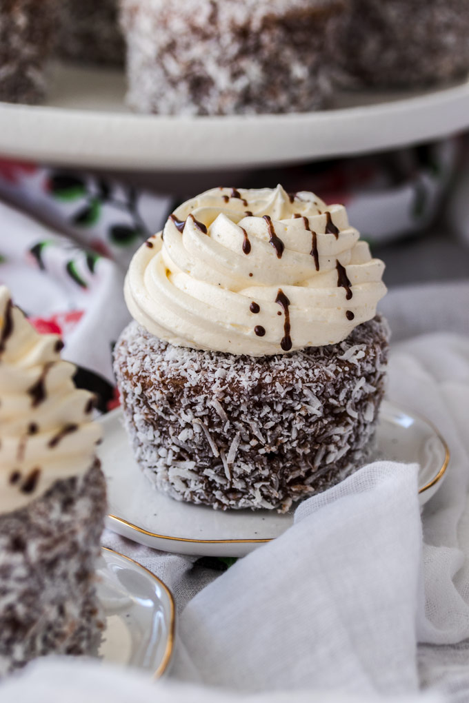 Lamington Cupcakes are those traditional little aussie cakes turned into a cupcake. A soft, fluffy vanilla cupcake, filled with jam and covered with an easy chocolate glaze and coconut.