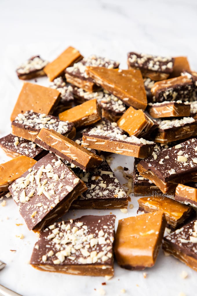 A pile of almond roca buttercrunch toffee covered in chocolate and almonds.