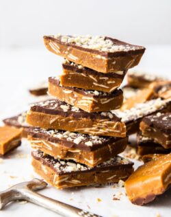 A stack of almond roca buttercrunch toffe,e covered in chocolate and almonds