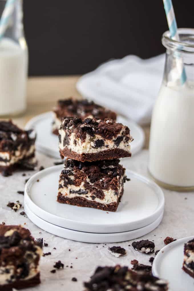 A stack of two oreo cheesecake bars on a white plate