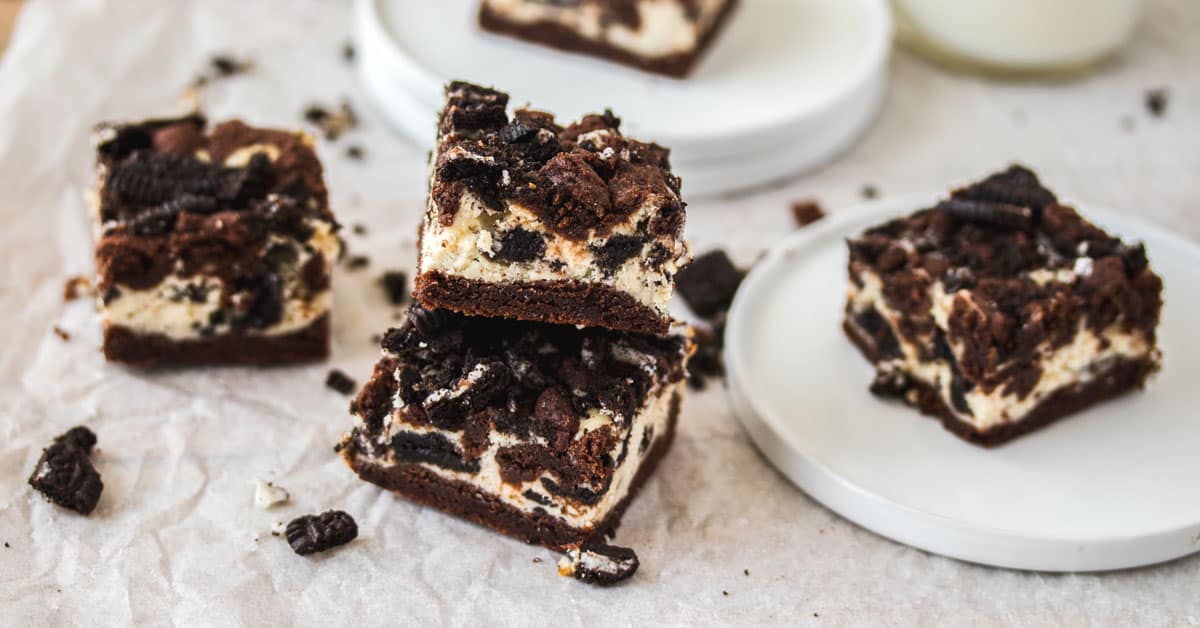 A stack of two oreo cheesecake bars on a white tablecloth