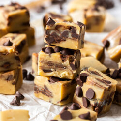 A stack of 3 cookie dough fudge pieces surrounded by more