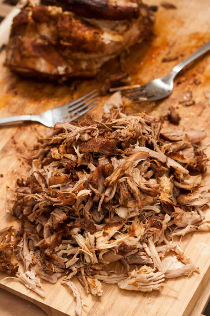 Pulled pork on a wooden chopping board.