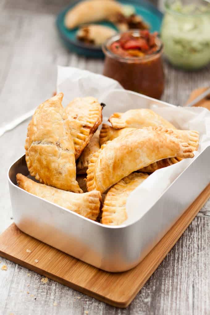 Close up of pulled pork empanadas in a metal tray.