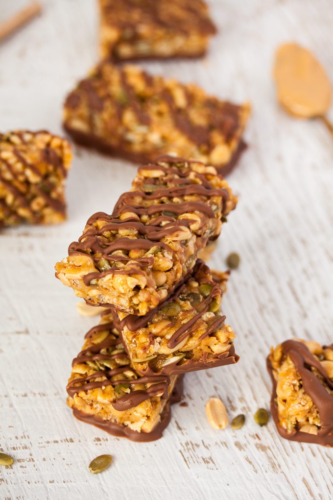 A stack of 3 trail mix bars drizzled with chocolate.