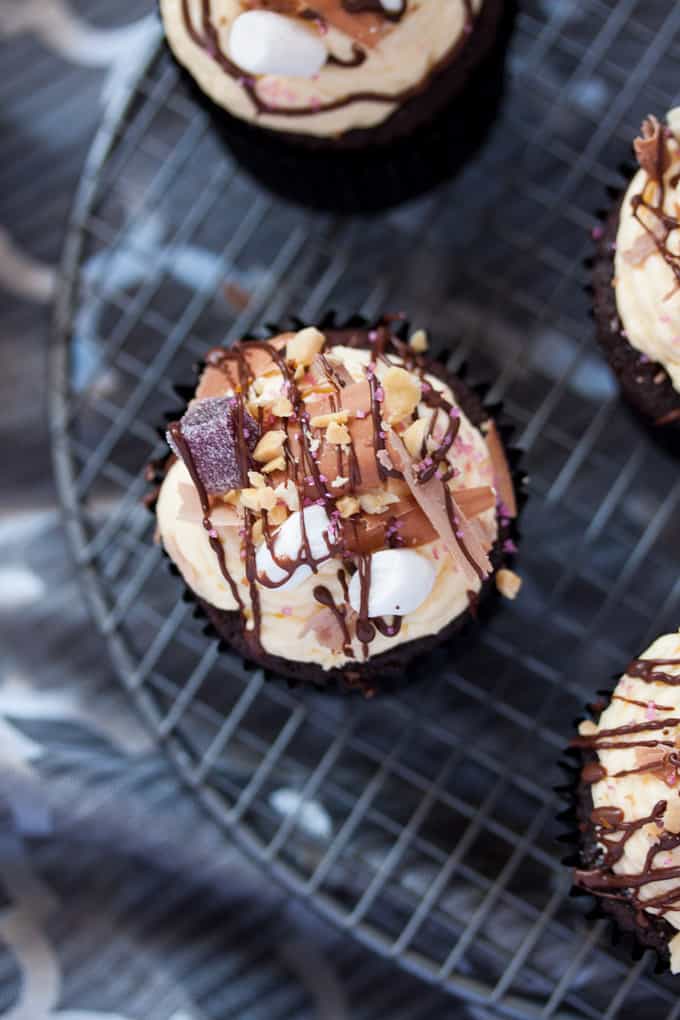 Top down view of a cupcake topped with chocolate, nuts and marshmallows.
