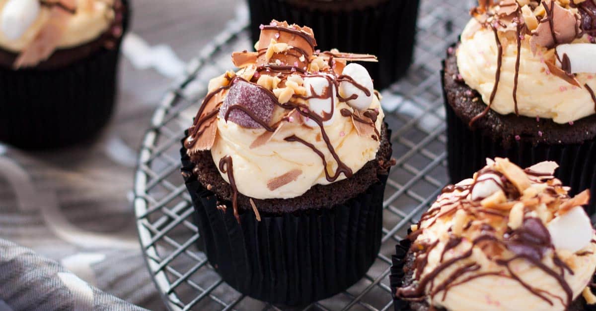 A chocolate cupcake topped with marshmallows, nuts and jellies.