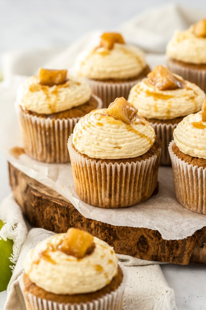 Apple pie cupcakes sitting on a wooden cake board