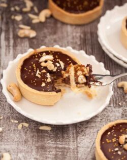 Nutty Caramel Chocolate Tarts - Almonds & cashews wrapped in caramel, fill a thin tart shell topped with Chocolate Ganache #nuts #baking