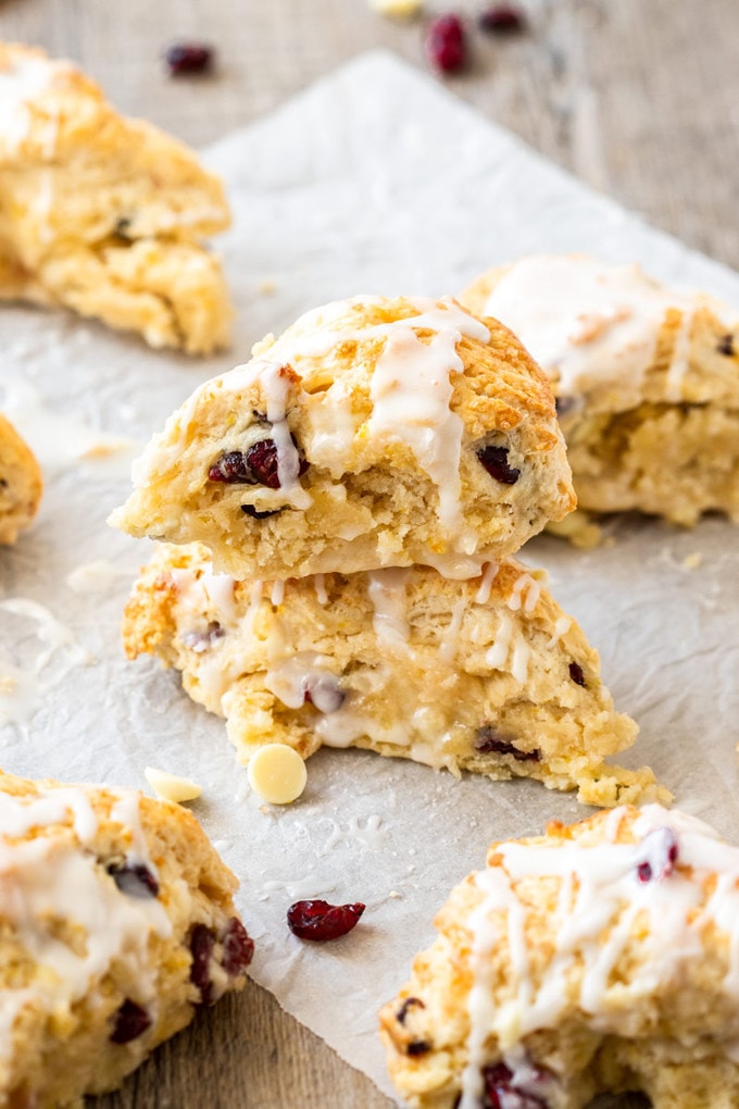 Two cranberry scones, one stack on top of the other, surrounded by more scones