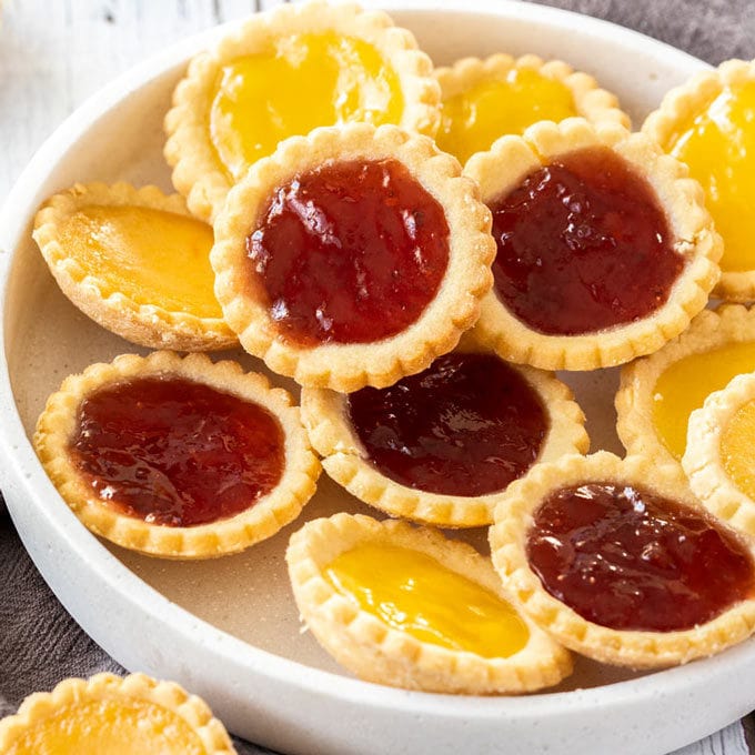 A white platter filled with jam tarts.