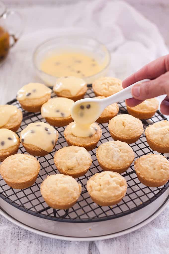 A batch of small round vanilla shortbreads with passionfruit icing over the top 