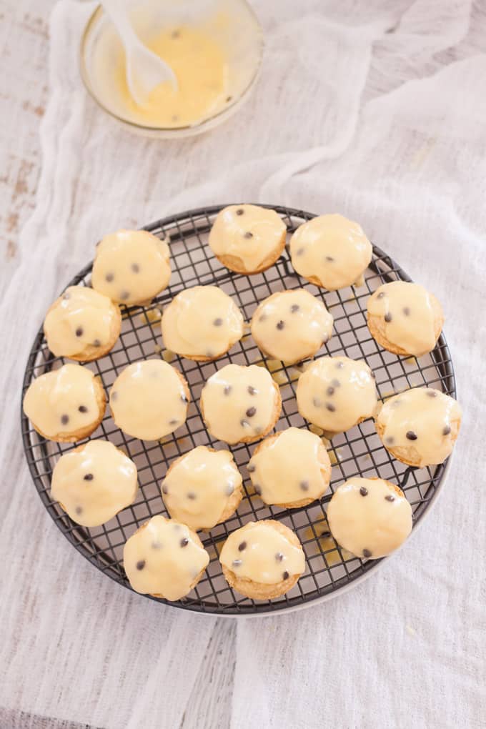 A batch of small round vanilla shortbreads with passionfruit icing over the top 