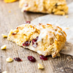 Closeup of a cranberry scone sitting on a wooden board