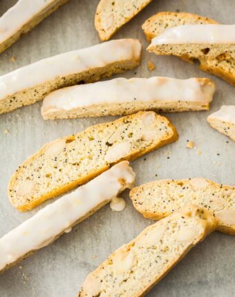 A group of lemon almond biscotti scattered on a sheet of baking paper
