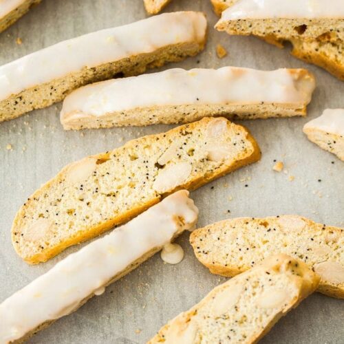 A group of lemon almond biscotti scattered on a sheet of baking paper