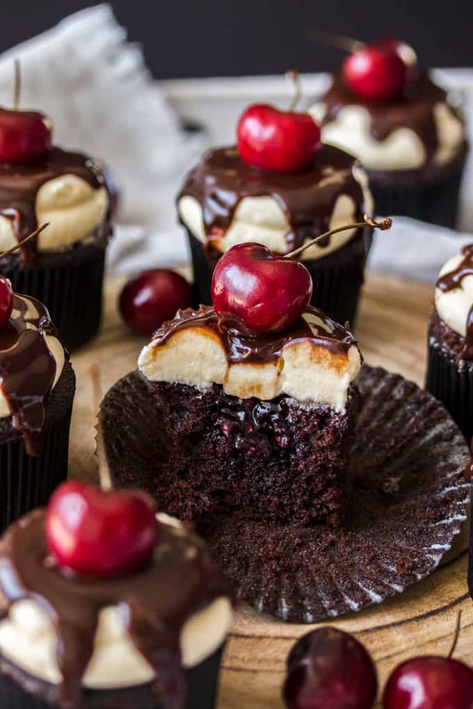 A cupcake cut open to show the cherry jam inside.
