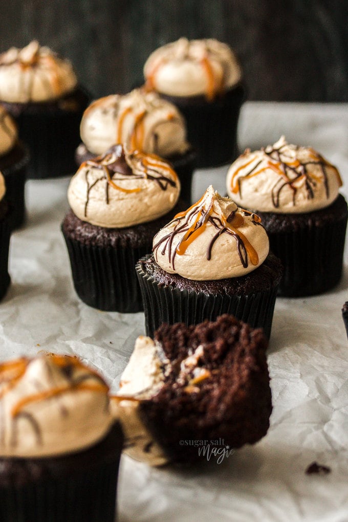 A chocolate cupcake topped with caramel buttercream and streaks of caramel sauce.
