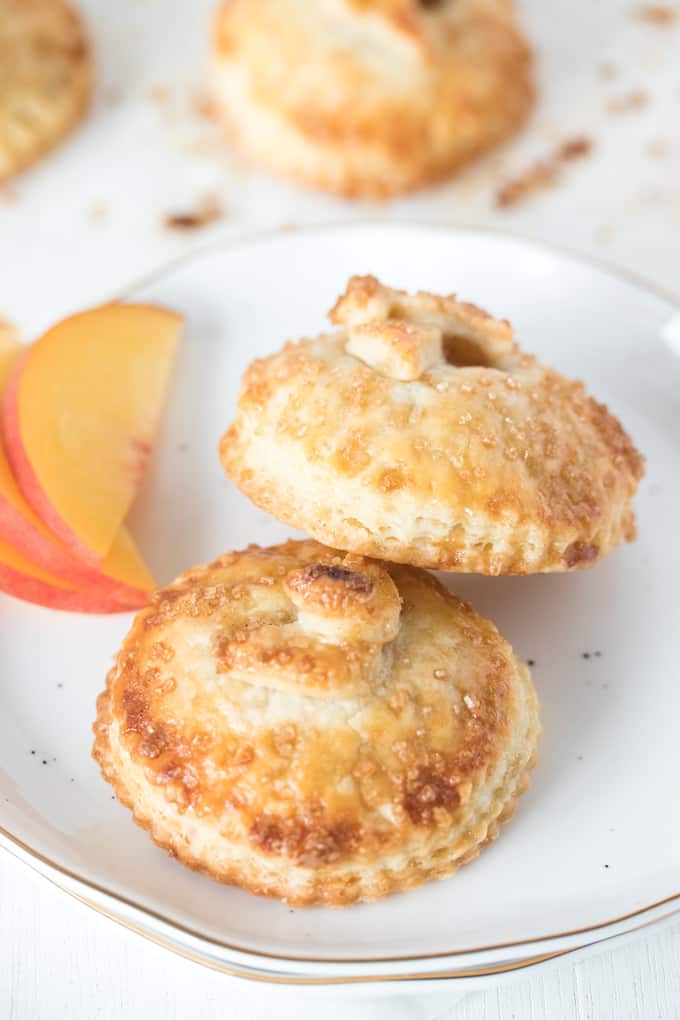 These Spiced Peach Hand Pies are a combination of fresh peaches, a kick of cinnamon and ginger, all wrapped up in the perfect buttery pie crust. These mini pies are the perfect portable dessert.