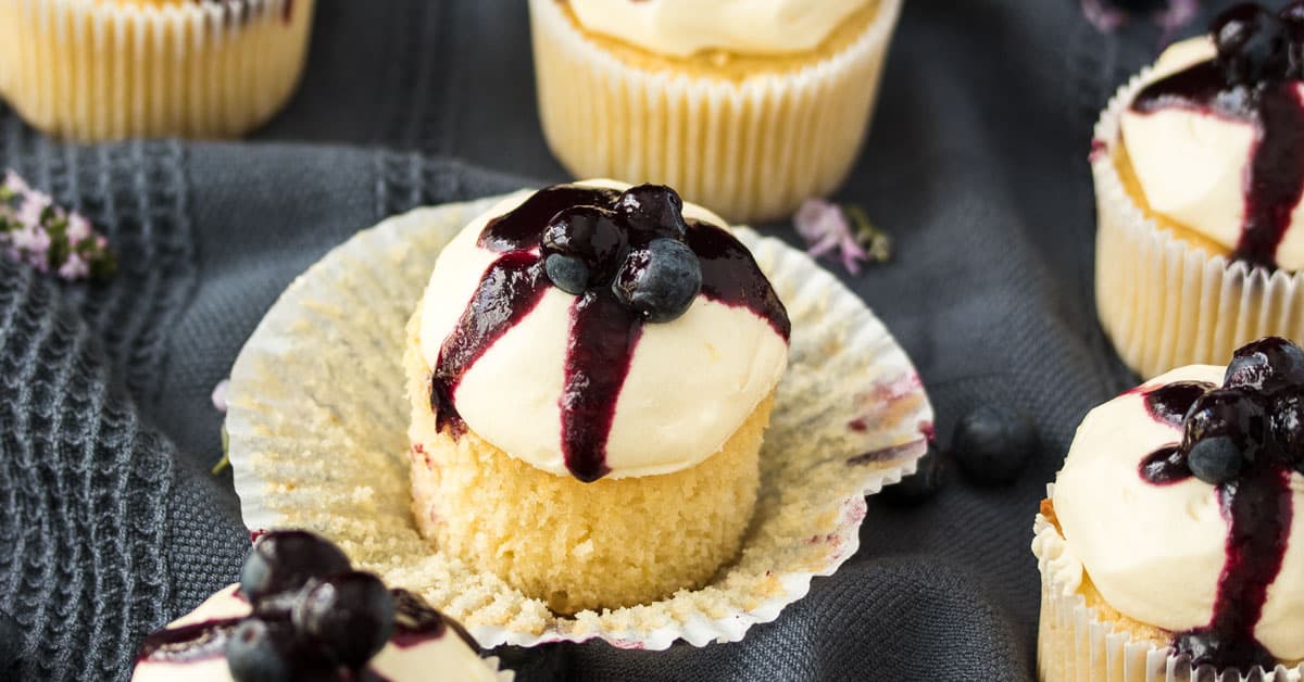 A Lemon Blueberry Cupcake with the cupcake paper peeled off.