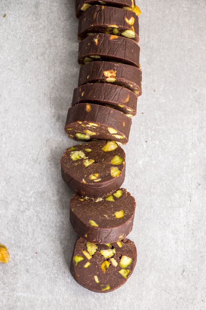 A log of Chocolate Pistachio Cookie dough cut into slices.
