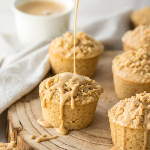 A Coffee Cake Muffin with coffee glaze being drizzled over the top