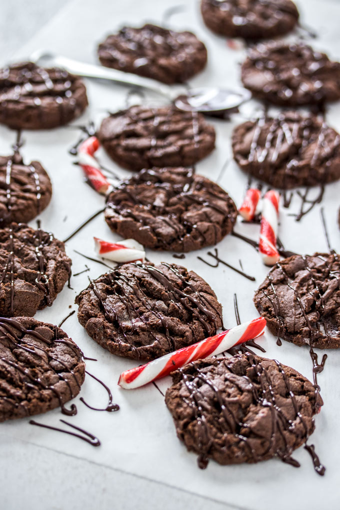Chocolate cookies surrounded by candy canes and melted chocolate drizzle.