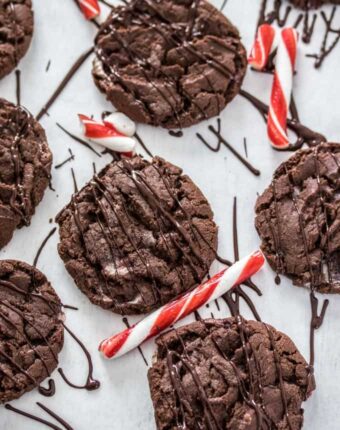 Chocolate cookies surrounded by candy canes and melted chocolate drizzle