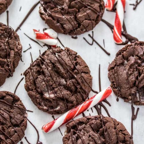 Chocolate cookies surrounded by candy canes and melted chocolate drizzle