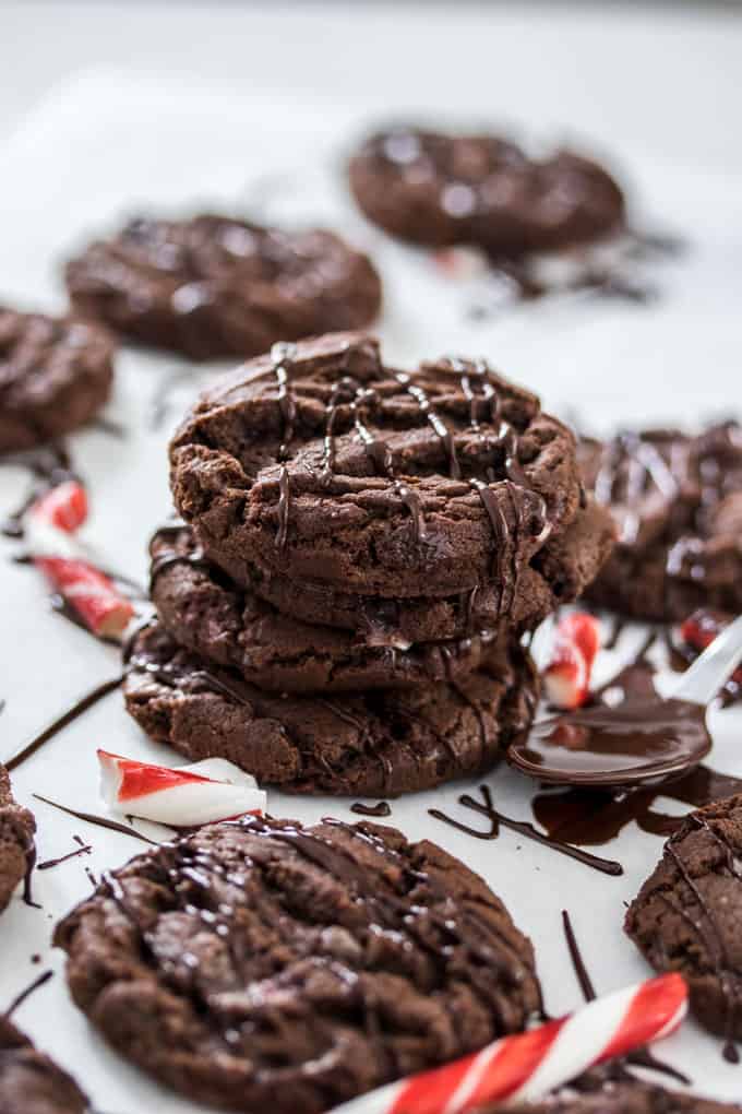 A stack of chocolate cookies surrounded by candy canes and melted chocolate drizzle.