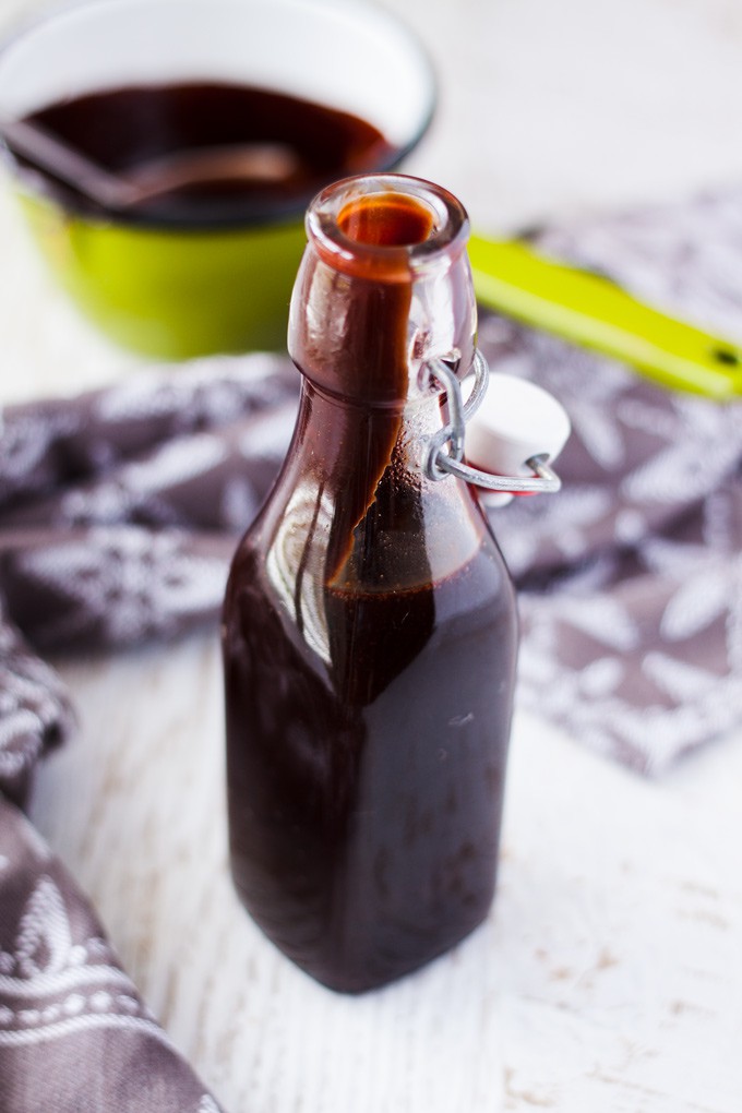 A glass bottle filled with Homemade Chocolate Sauce.