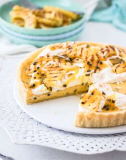 This Passionfruit Tart is a simple passionfruit curd custard filling in a crisp tart shell. It's all topped with grilled pineapple slices and coconut. Tropical tart heaven.
