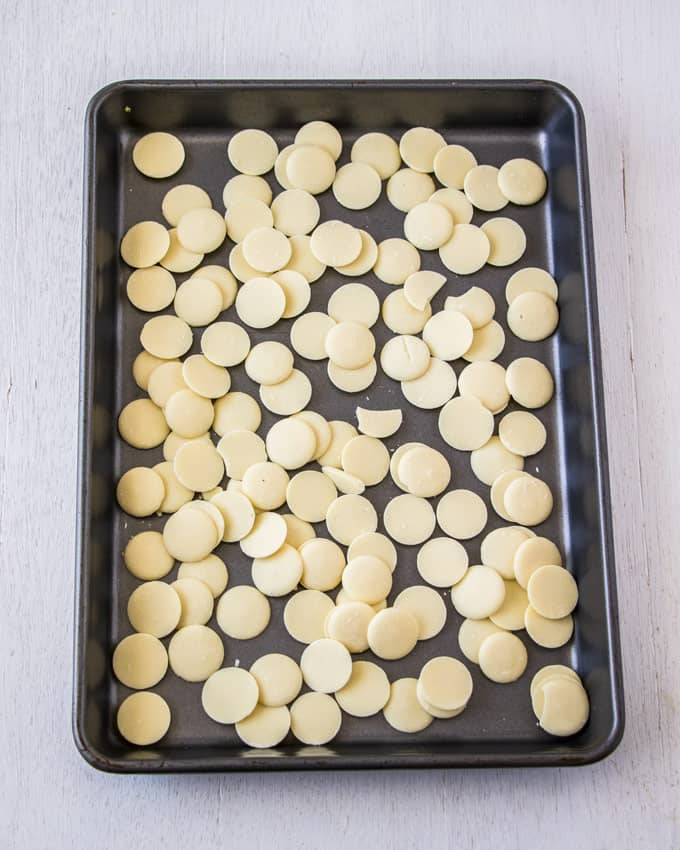 A baking tray covered with large white chocolate chips.