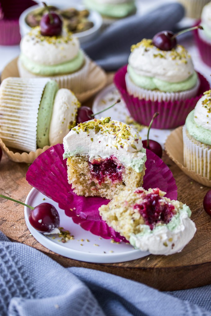 A Cherry Pistachio Cupcake cut open to reveal the filling inside.