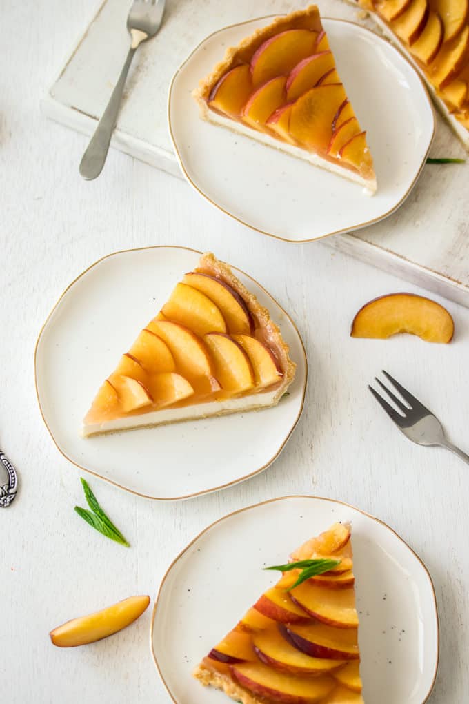 3 slices of Panna Cotta Fresh Peach Tart on white plates