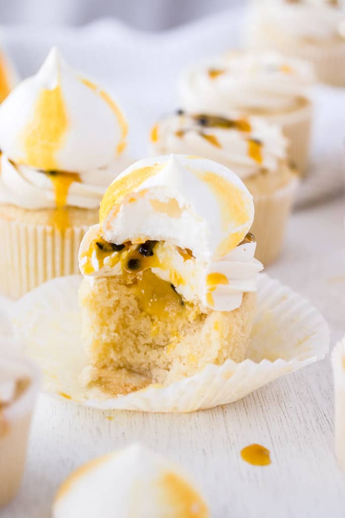 A Passionfruit Coconut Cupcake cut open to show the filling inside.
