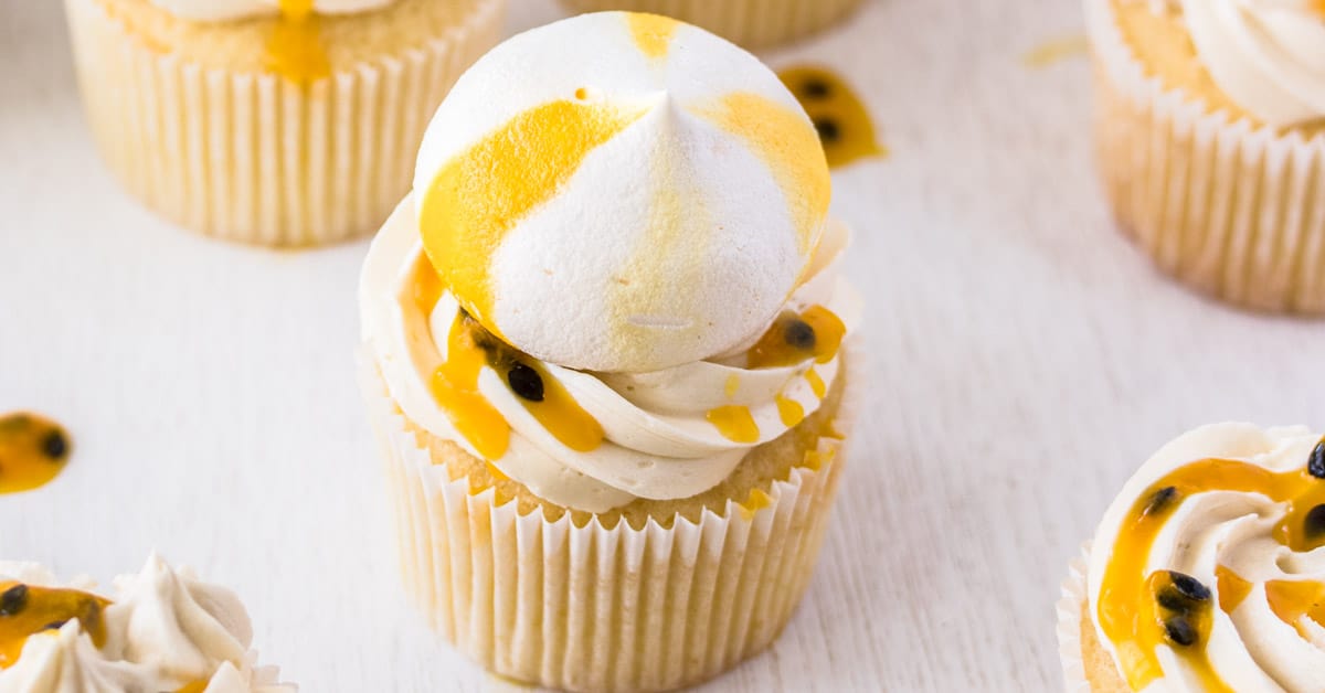 A Passionfruit Coconut Cupcake topped with a yellow and white meringue kiss. 
