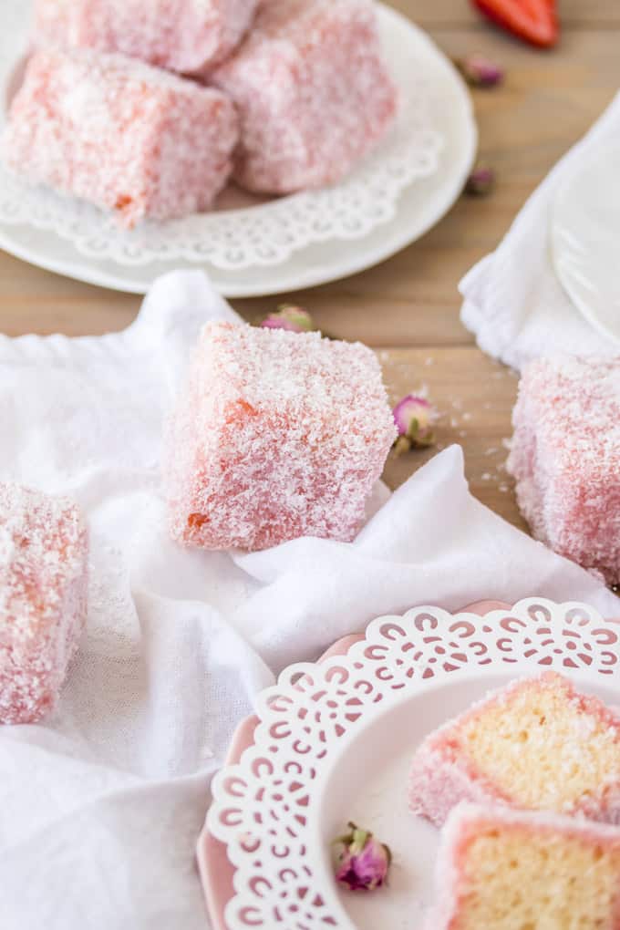 Rose Strawberry Lamingtons on white and pink plates next to a white towel