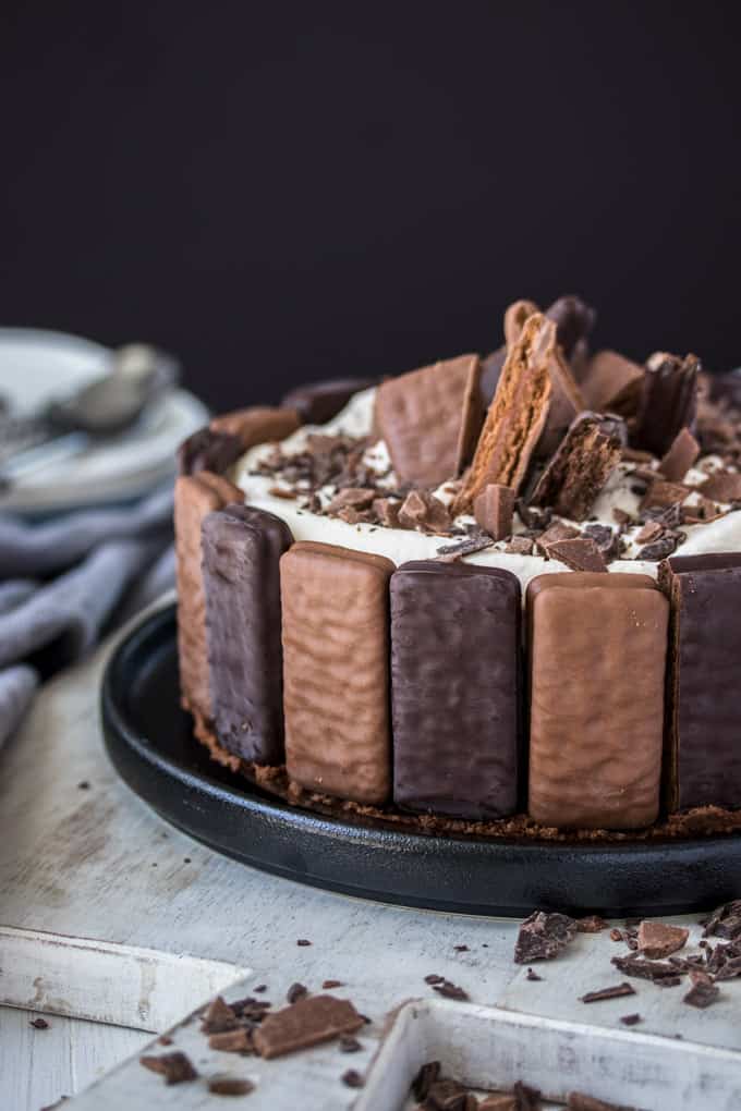 A No Bake Tim Tam Cheesecake with Tim Tams around the edges and pieces of Tim Tam on top