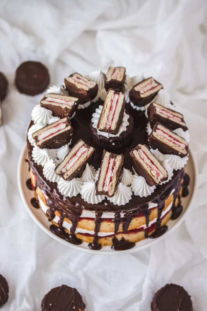 A Wagon Wheel Cake on  a cake stand, mini wagon wheels scattered around on a white sheet