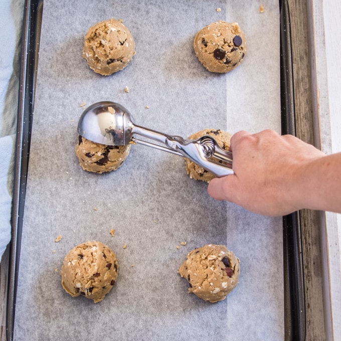 Placing cookie dough onto a baking tray with a cookie scoop