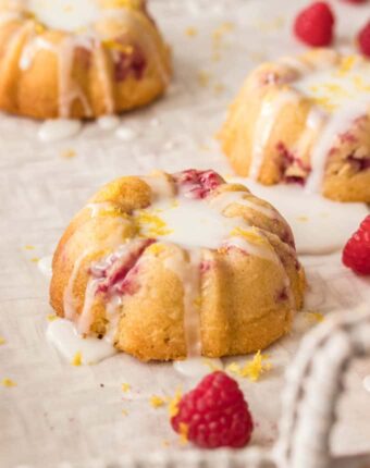 These Lemon Raspberry Mini Bundt Cakes are a simple lemon cake recipe, studded with fresh raspberries and topped with lemon icing, all baked in a mini bundt pan.