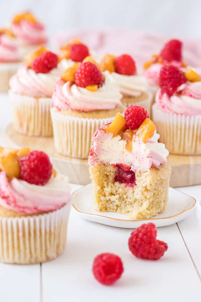 A Peach Melba Cupcake cut open to reveal the filling inside
